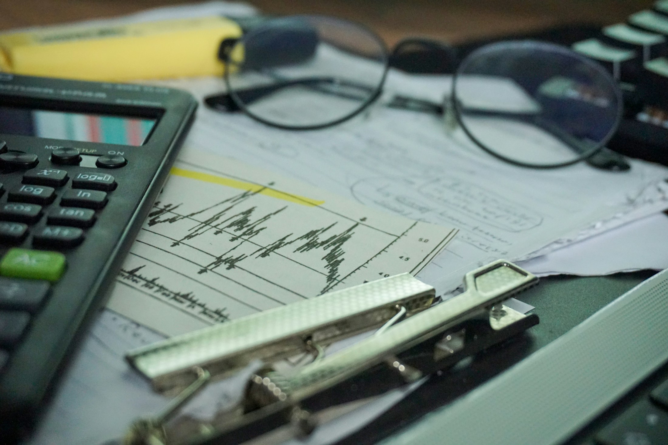 Calculator and market charts on a finance desk